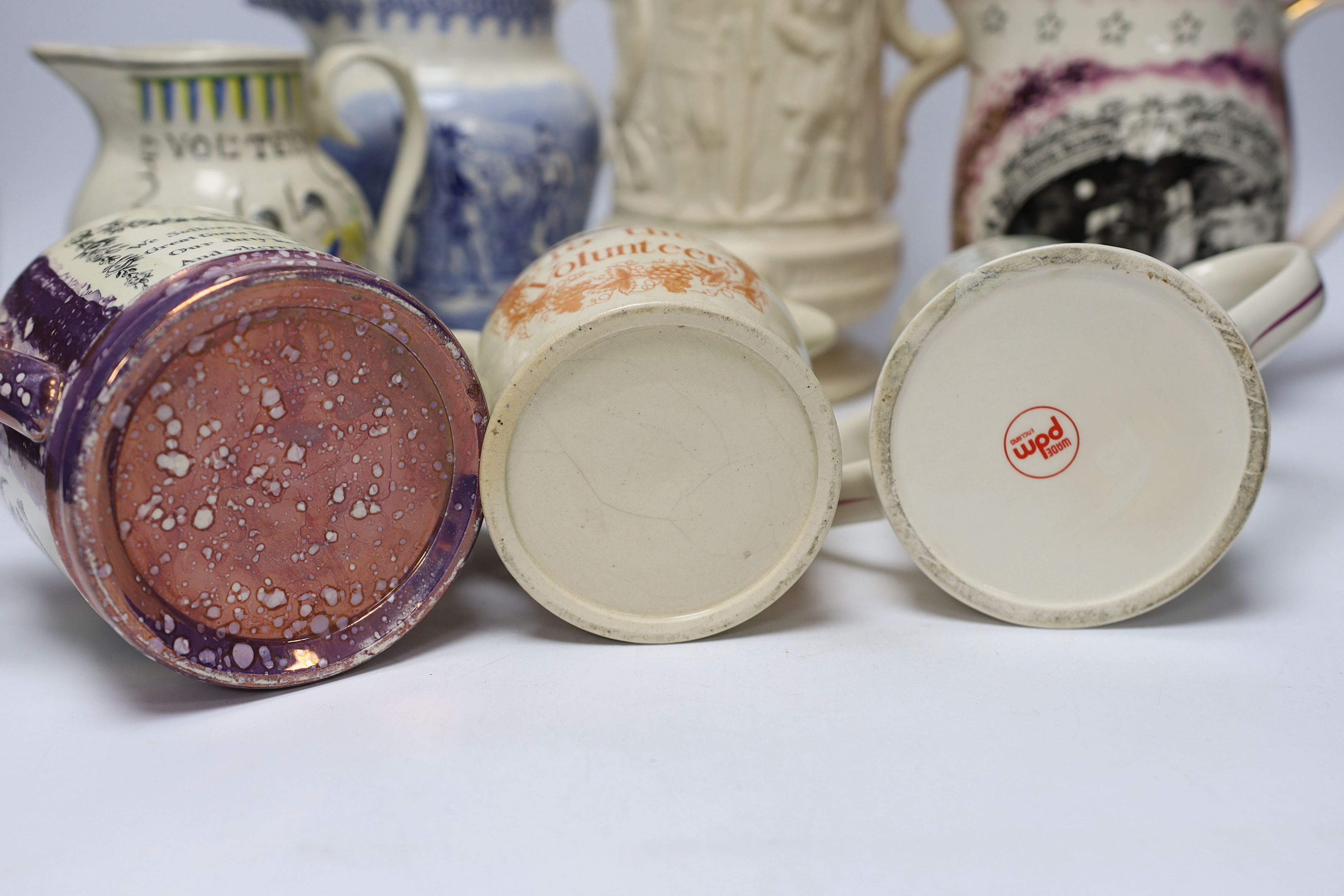 Seven military and naval themed jugs including a Leeds creamware jug 'Loyal Volunteers' inscribed 'L Volnteers' c.1803, an early 19th century success to the volunteers jug, a Sunderland pink splash lustre loving cup etc.